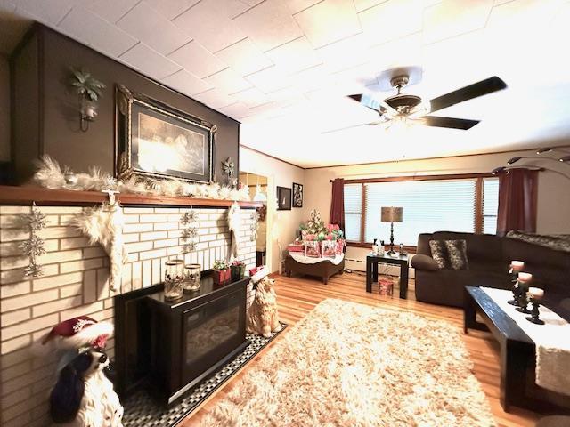 living room with ceiling fan and light wood-type flooring