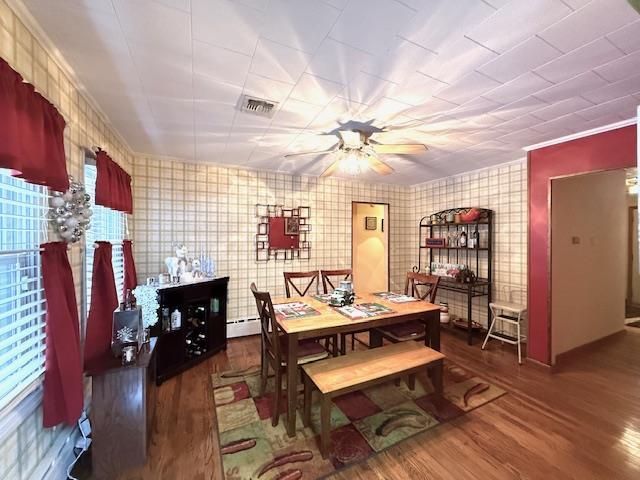 dining area with ceiling fan, a baseboard radiator, dark hardwood / wood-style floors, and ornamental molding