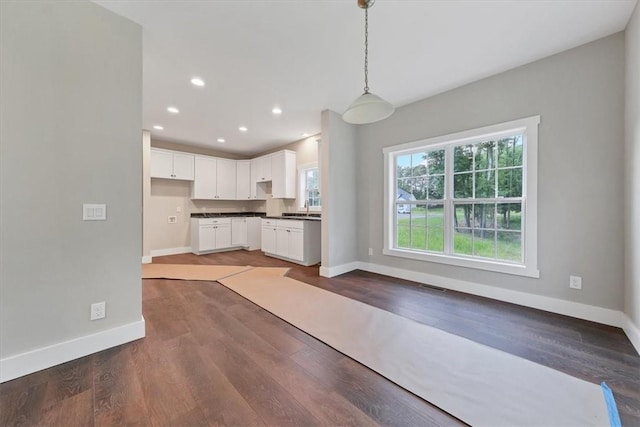 kitchen with pendant lighting, dark hardwood / wood-style flooring, white cabinetry, and sink