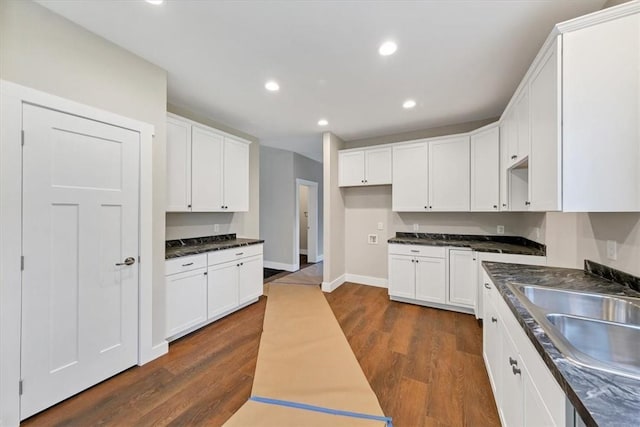 kitchen with dark hardwood / wood-style floors, white cabinetry, and sink