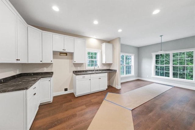 kitchen with sink, white cabinets, dark hardwood / wood-style floors, and decorative light fixtures