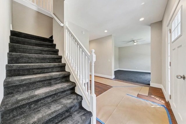 stairs with wood-type flooring and ceiling fan