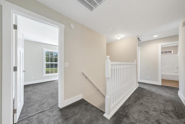 hall with dark colored carpet