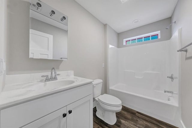 full bathroom with hardwood / wood-style flooring, vanity, toilet, and shower / bath combination