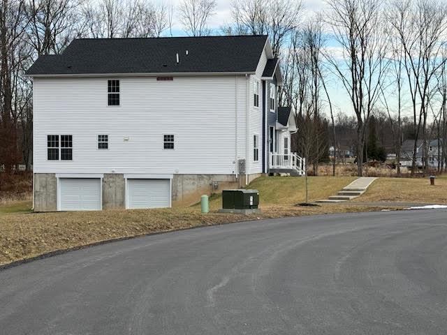 view of property exterior with a garage and central air condition unit