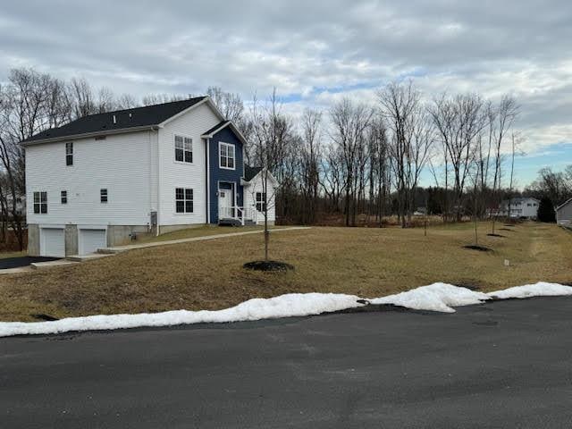 view of home's exterior with a yard and a garage