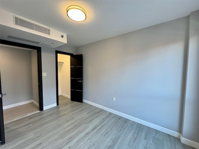 unfurnished bedroom with a closet and light hardwood / wood-style floors