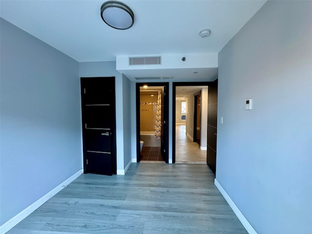 interior space featuring ensuite bath and light wood-type flooring