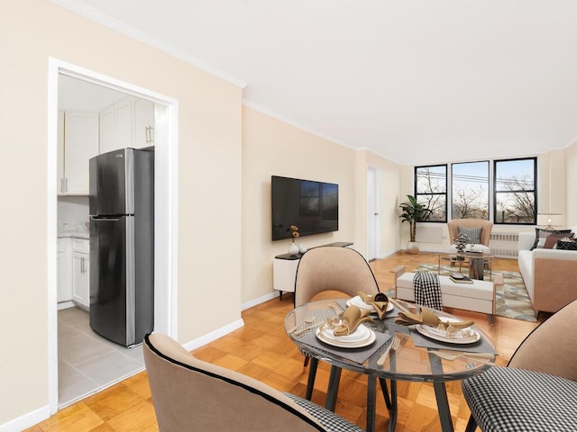 living room with light hardwood / wood-style floors, radiator heating unit, and crown molding