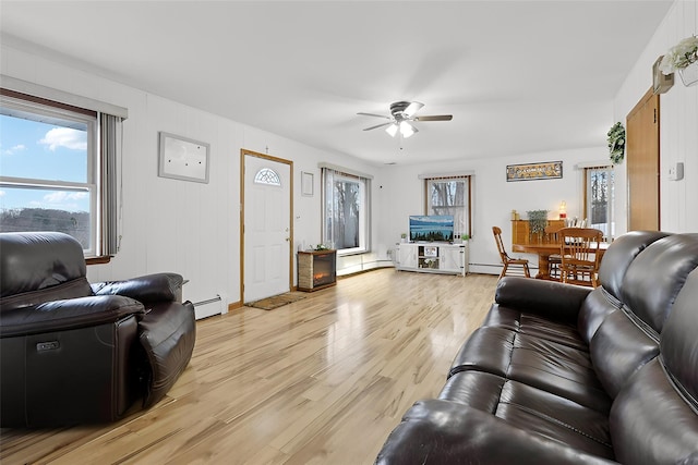 living room featuring light wood-type flooring, ceiling fan, and a baseboard heating unit