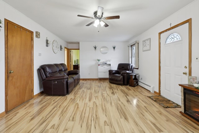 living room with ceiling fan, a baseboard heating unit, and light wood-type flooring