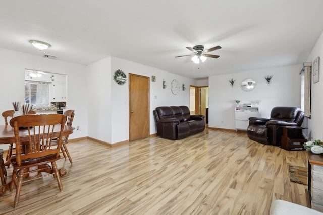 living room with light wood-type flooring and ceiling fan