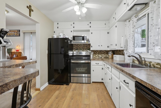 kitchen with black appliances, white cabinets, and sink