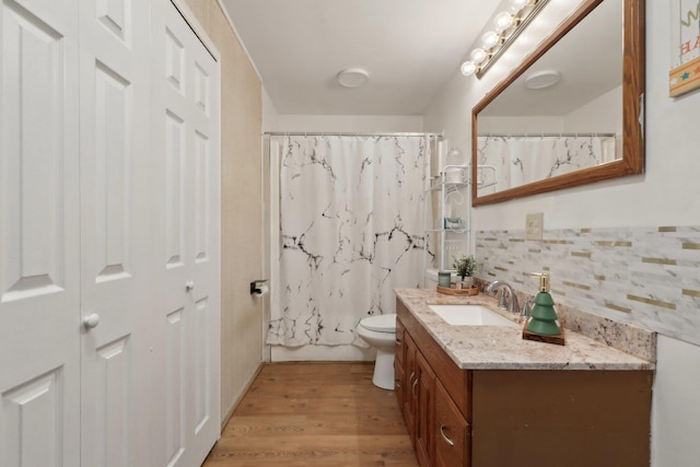 full bathroom with wood-type flooring, vanity, toilet, and shower / bath combination with curtain