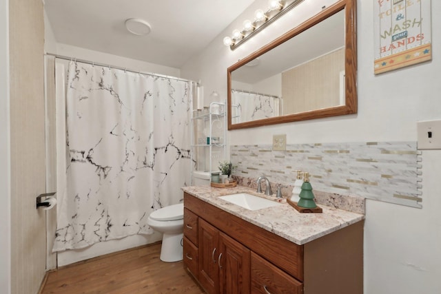 full bathroom featuring shower / bath combination with curtain, tasteful backsplash, vanity, hardwood / wood-style flooring, and toilet