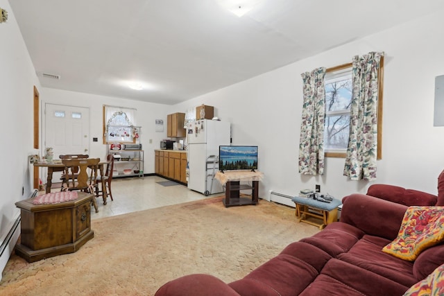 living room featuring a healthy amount of sunlight and a baseboard heating unit