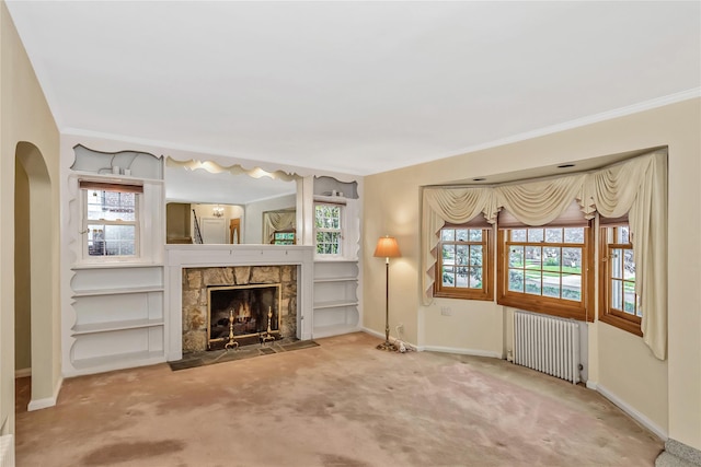 unfurnished living room with radiator, carpet floors, baseboards, and ornamental molding