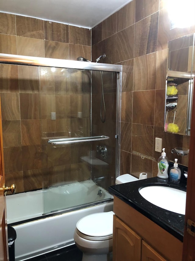 full bathroom featuring vanity, enclosed tub / shower combo, and toilet