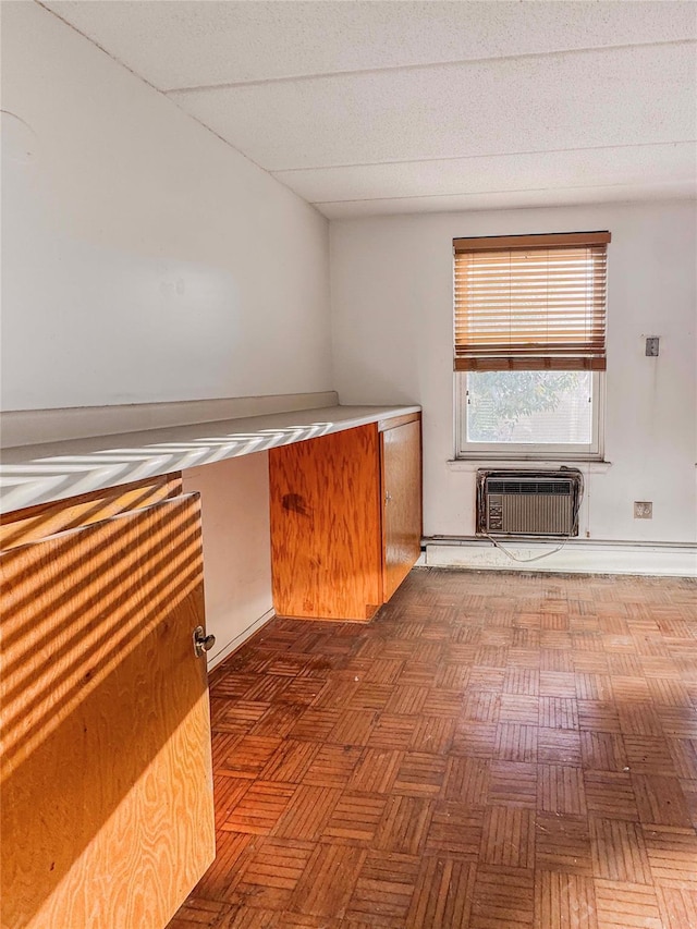 interior space featuring a wall mounted AC and dark parquet flooring