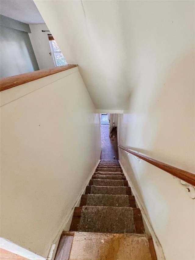 staircase featuring lofted ceiling