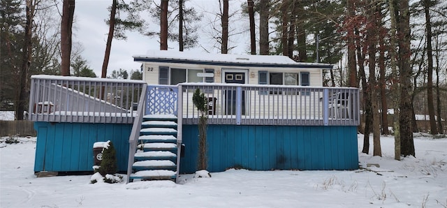 snow covered house with a wooden deck