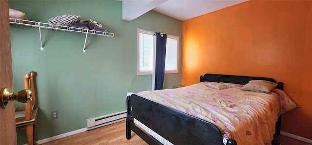 bedroom featuring hardwood / wood-style floors and baseboard heating