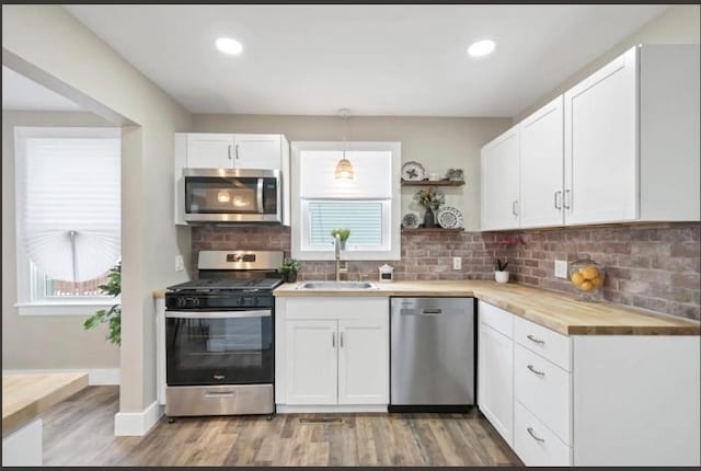 47 Prince St, Middletown, NY 10940 - kitchen with stainless steel appliances, a sink, light wood-style floors, white cabinetry, and open shelves