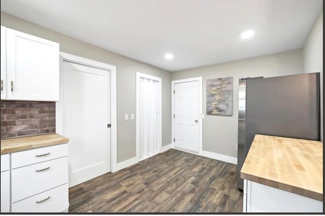 47 Prince St, Middletown, NY 10940 - kitchen with butcher block counters, white cabinets, tasteful backsplash, dark wood finished floors, and baseboards