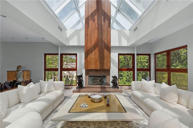 living room featuring a wealth of natural light, a fireplace, and a high ceiling