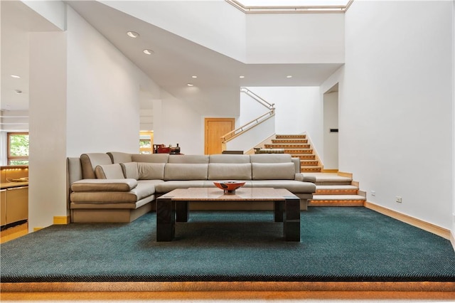 carpeted living room with a high ceiling