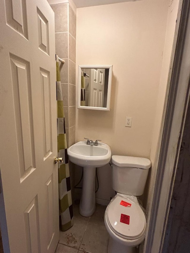 bathroom featuring sink, tile patterned flooring, and toilet