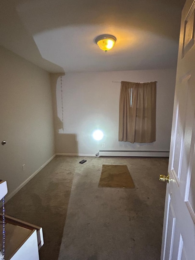 unfurnished room featuring a baseboard radiator and dark colored carpet