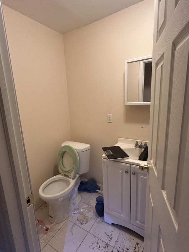 bathroom featuring tile patterned flooring, vanity, and toilet