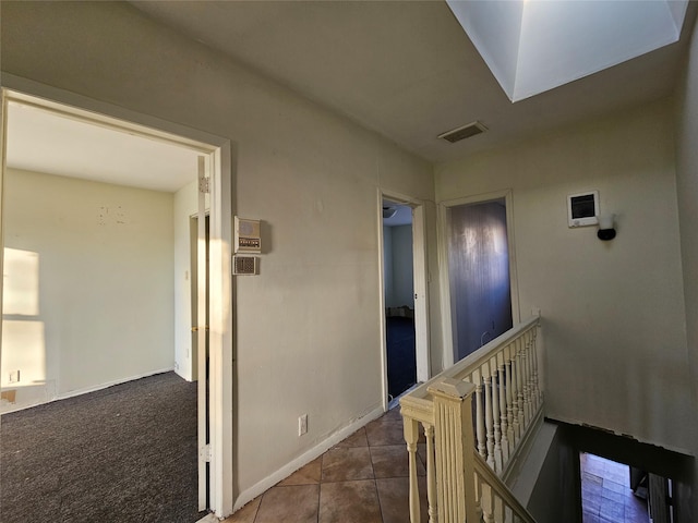 corridor featuring tile patterned floors and a skylight