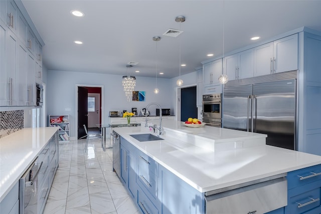 kitchen featuring built in appliances, a spacious island, sink, and pendant lighting