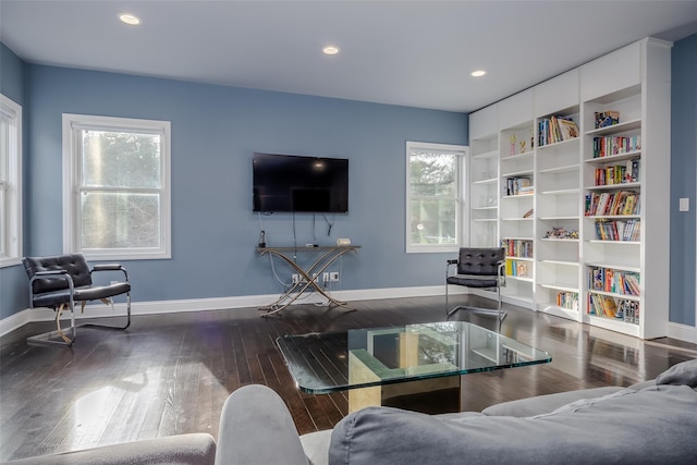 living room featuring wood-type flooring, plenty of natural light, and built in shelves