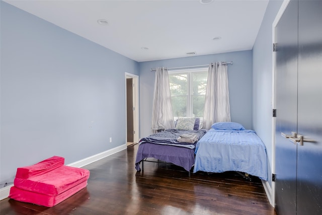 bedroom with dark hardwood / wood-style flooring