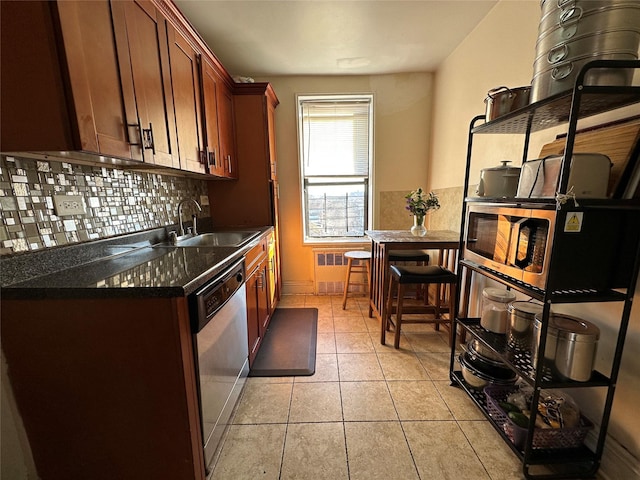 kitchen featuring decorative backsplash, stainless steel dishwasher, radiator, sink, and light tile patterned floors