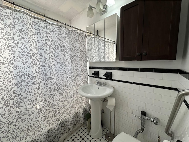 bathroom featuring tile patterned flooring, toilet, and tile walls