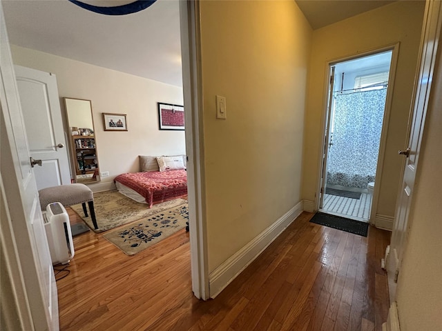 corridor with hardwood / wood-style flooring