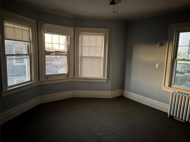 unfurnished room featuring dark colored carpet, a wall unit AC, ornamental molding, and radiator