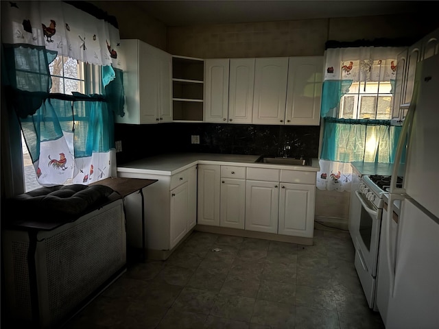 kitchen featuring white cabinets, a healthy amount of sunlight, white appliances, and sink