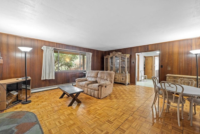 living room with light parquet flooring, a baseboard heating unit, and wood walls