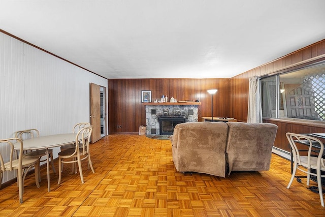 living room with light parquet floors, a stone fireplace, and wooden walls