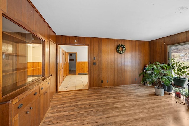 interior space with light hardwood / wood-style floors and wooden walls