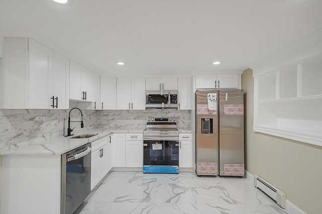 kitchen featuring light stone counters, stainless steel appliances, sink, a baseboard radiator, and white cabinetry