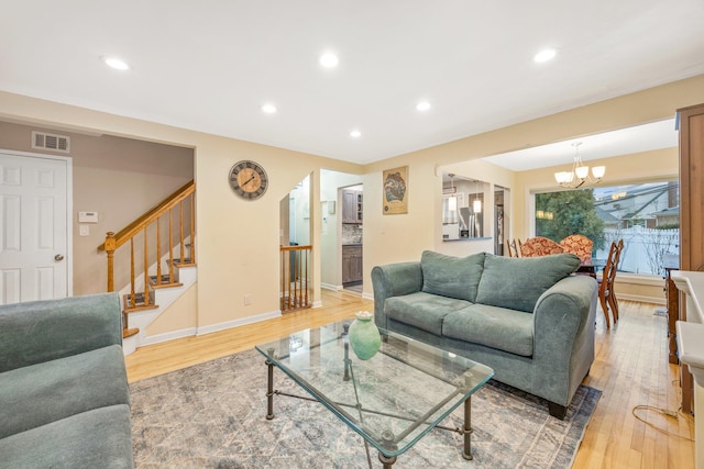 living room with an inviting chandelier and hardwood / wood-style flooring