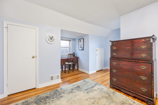 bedroom featuring light hardwood / wood-style flooring and lofted ceiling