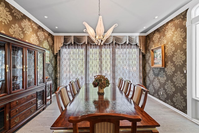 dining area featuring hardwood / wood-style flooring, ornamental molding, and an inviting chandelier