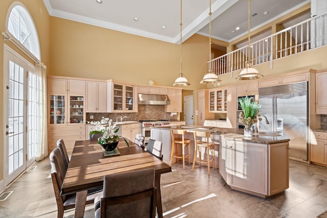 dining area featuring plenty of natural light, a towering ceiling, and french doors